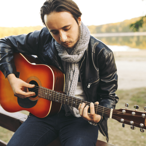 young-man-playing-guitar-lake
